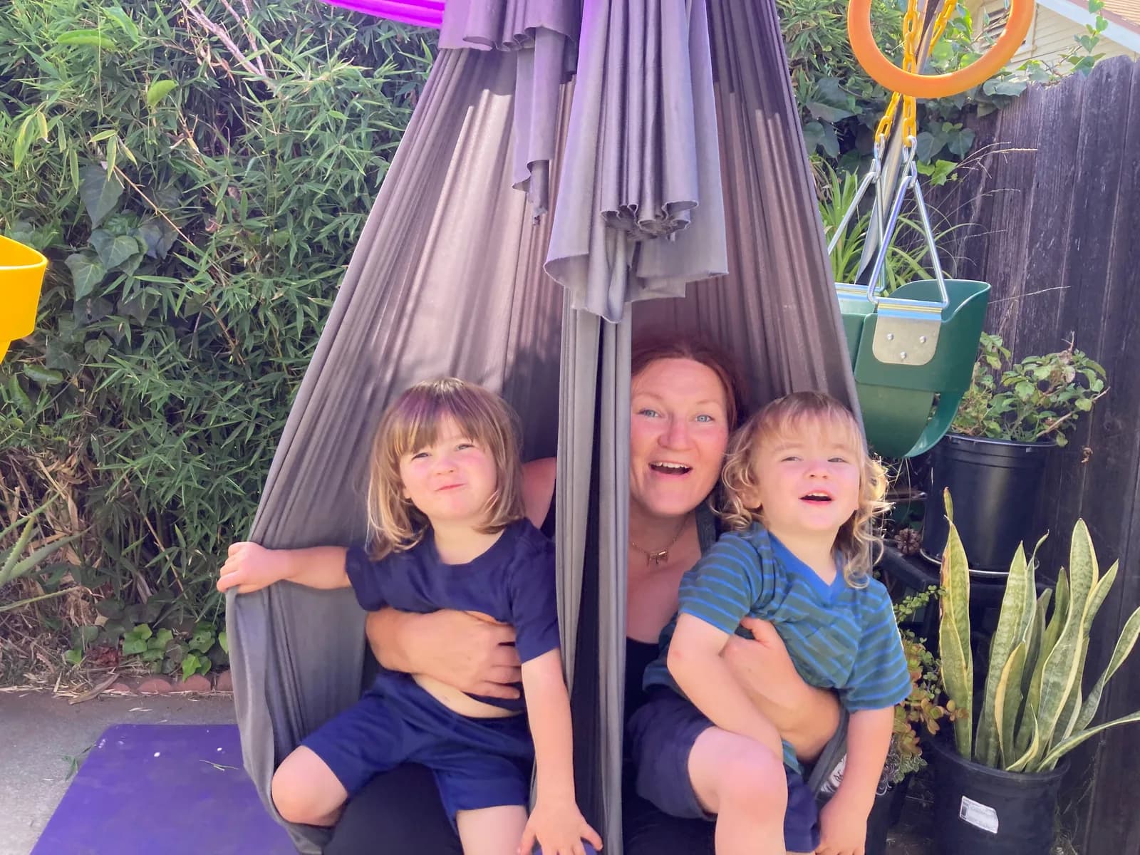 Hannahsita sitting in aerial fabric with two children