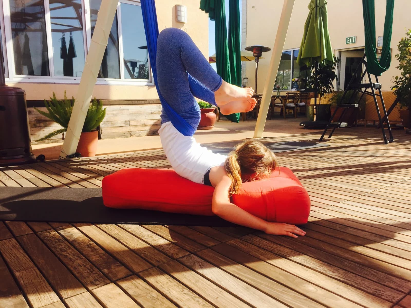 A child practicing an aerial movement above supportive floor cushions